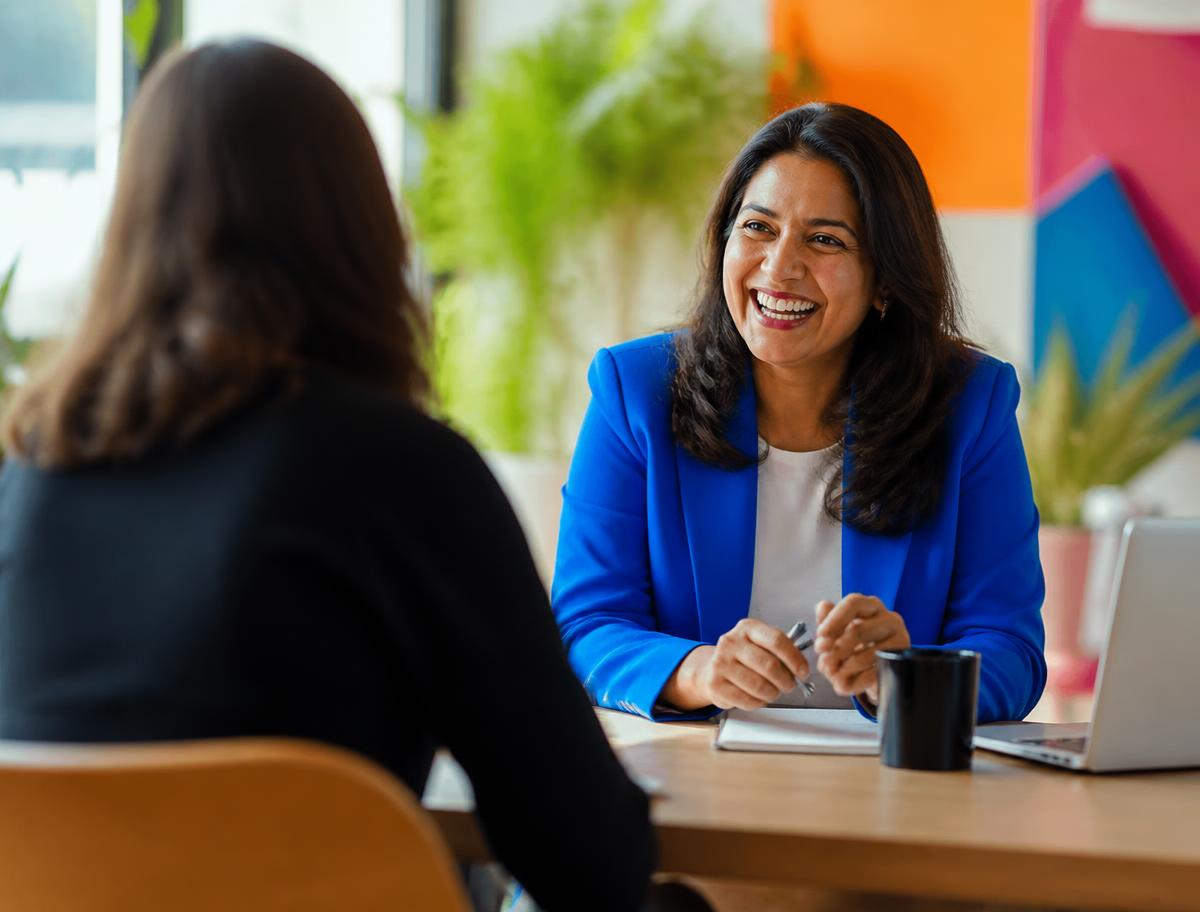 A manager and new hire laughing during an onboarding chat