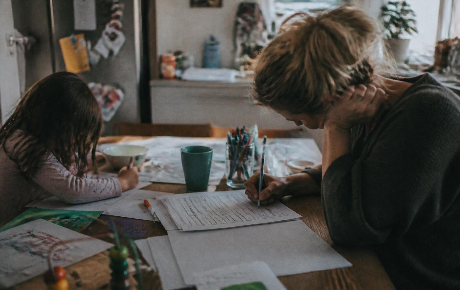 A parent completing a custody schedule at the kitchen table