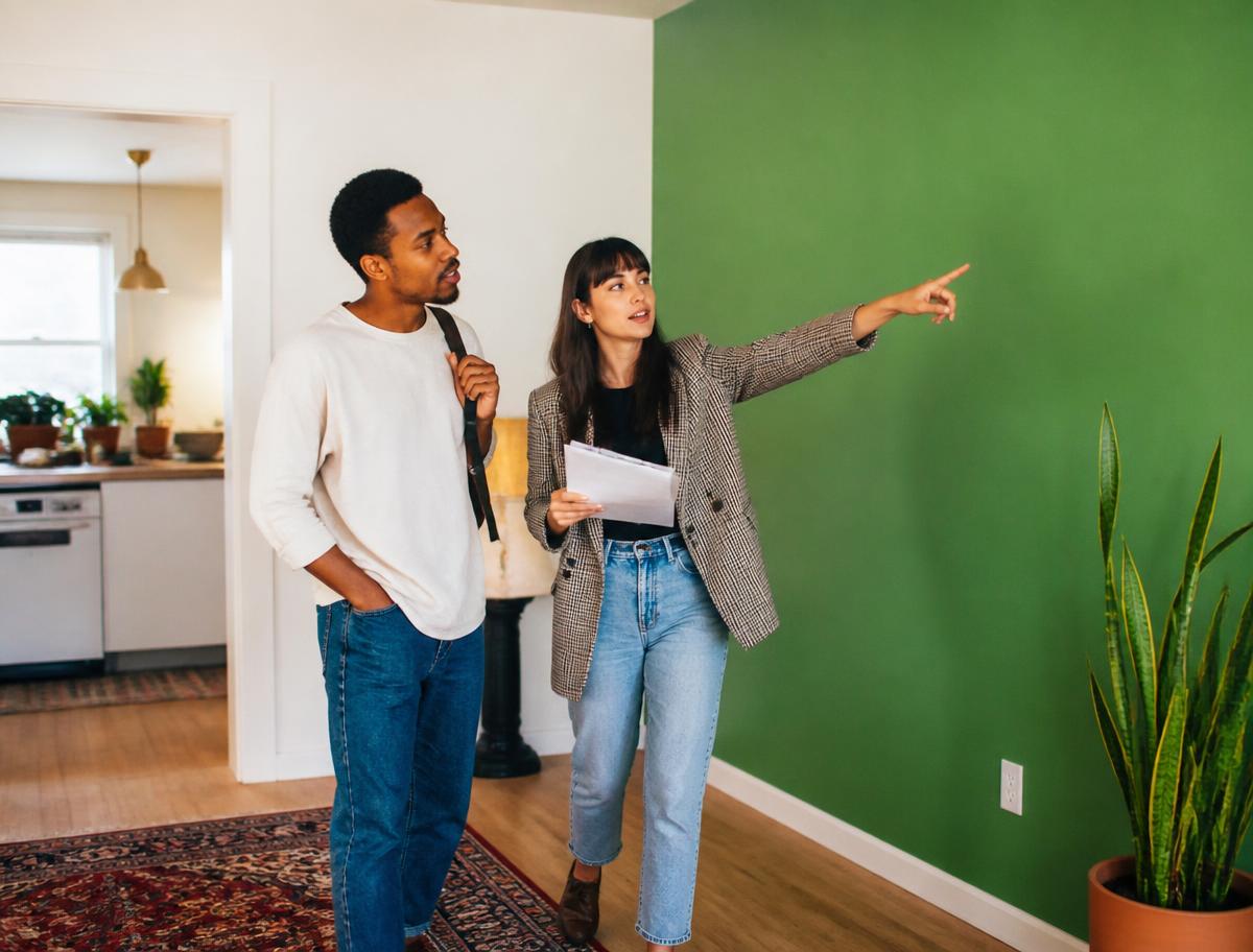 A landlord and tenant chatting in a sunlit living room