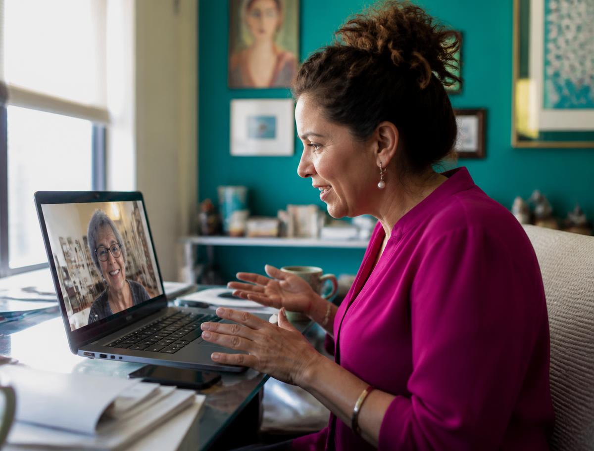 An adult child helping a parent with a laptop at home
