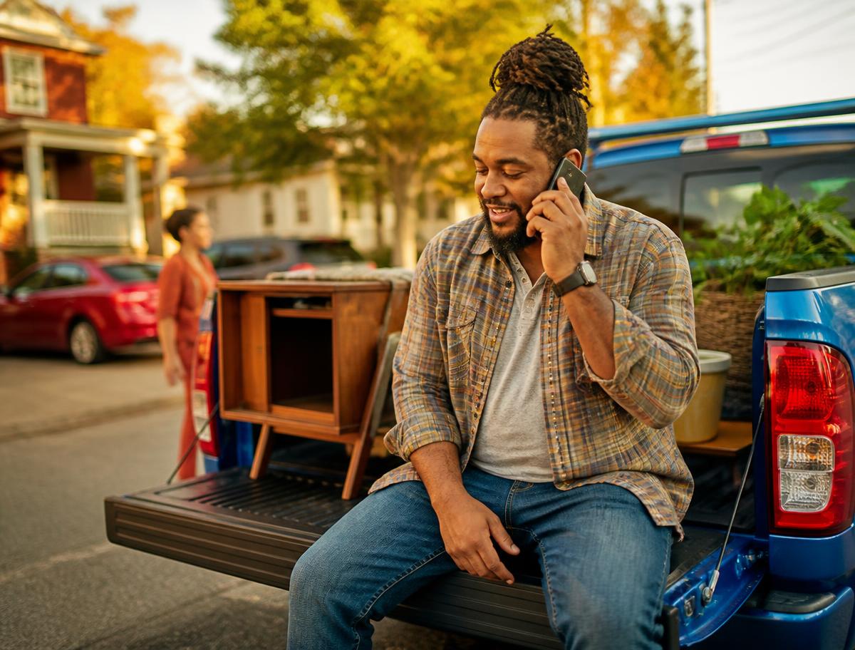 A buyer checking over a car in bright daylight