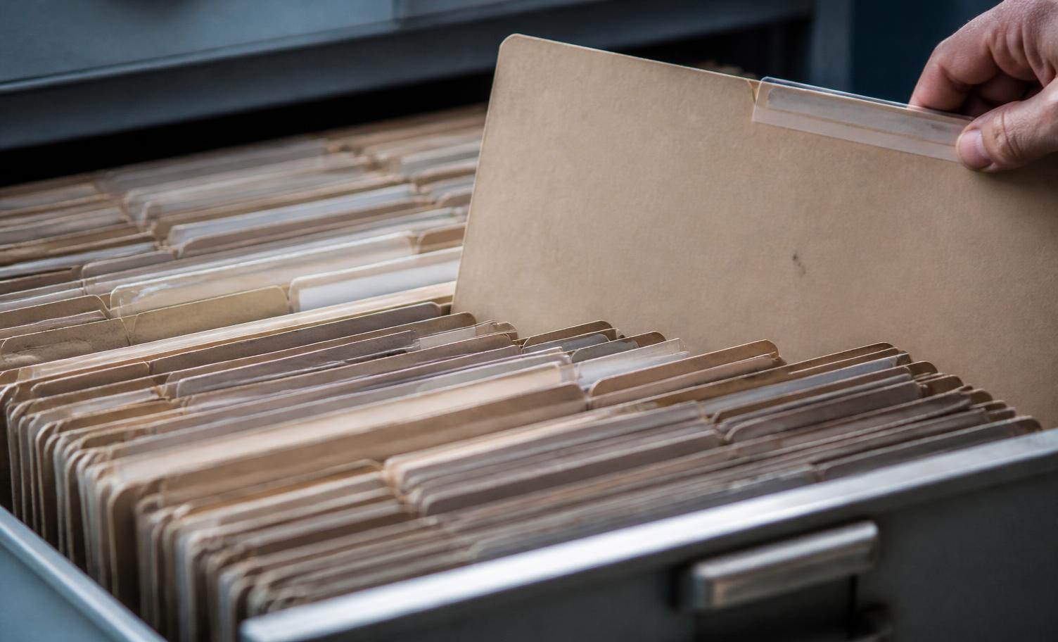 Labelled document folders in an open filing drawer